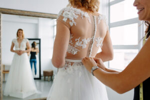 Sposa che prova l'abito con schiena effetto tattoo nude