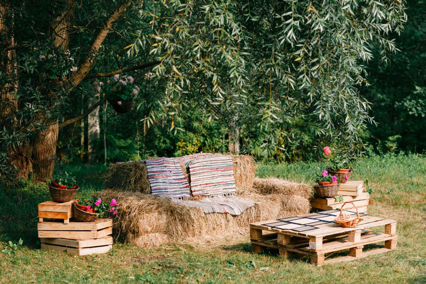 Zona relax allestita in stile country con balle di paglia e cassette di legno