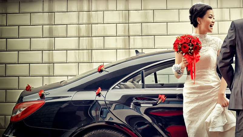 Auto degli sposi decorata con fiorellini rossi sparsi