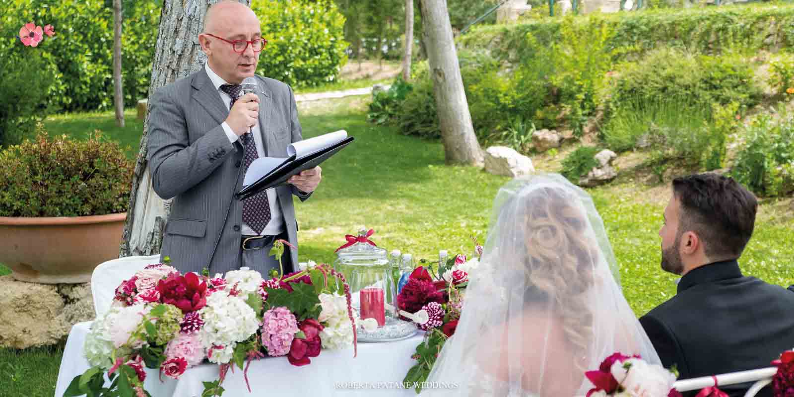 Celebrante e sposi durante il rito simbolico all'aperto