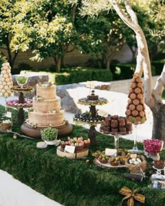 Tavolo del buffet di dolci ricoperto con il prato per il tema Alice nel Paese delle Meraviglie