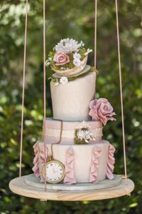 Torta a ripiani sbilenchi sospesa su un'altalena - Tema Alice nel Paese delle Meraviglie